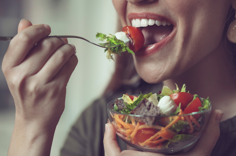 Frau genießt gesunden Salat mit frischen Zutaten