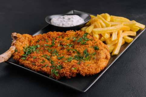 Panéiert Schnitzel mat Fritten an Zooss Garnéierung